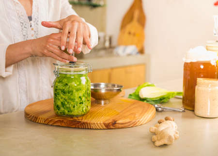 Preparing fermented preserved vegetables. Jars of cabbage kimchi and sauerkraut sour cabbage.の写真素材