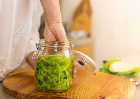 Preparing fermented preserved vegetables. Jars of cabbage kimchi and sauerkraut sour cabbage.の写真素材
