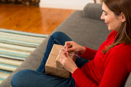 Beautiful woman at home wrapping presents for Christmasの写真素材