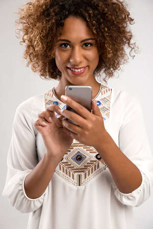 Beautiful African American woman texting somenone