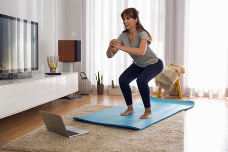 Full length shot of a woman doing exercise at home