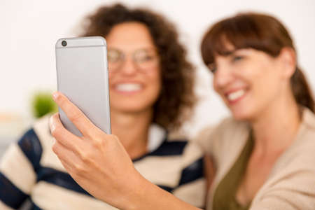 Two beautiful firends at home making  a selfieの写真素材