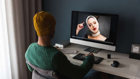 Man working at home editing pictures on computerの写真素材