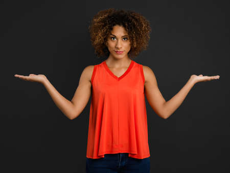 Beautiful African American woman with arms open making a scale with handsの写真素材