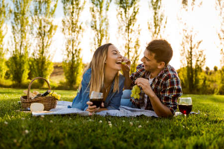 Shot of a happy couple enjoying a day in the park making a picnicの写真素材