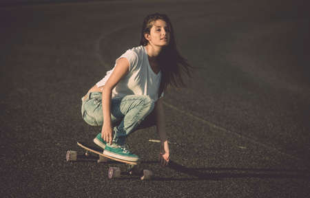 Young woman makign a downhill with her skateboardの写真素材