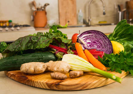 Several vegetables on top of a wooden board. Ingredients for detox diet. 