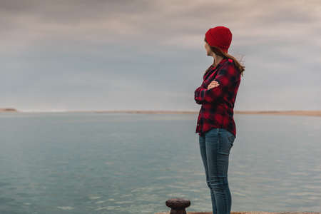 Beautiful woman felling cold near the lakeの写真素材