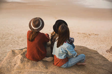 Three best friends near the coastline looking to the seaの写真素材