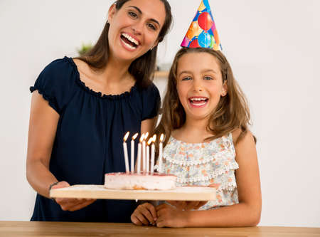 Shot of a mother and daughter in the kitchen celebrating Daughter's birthdayの写真素材