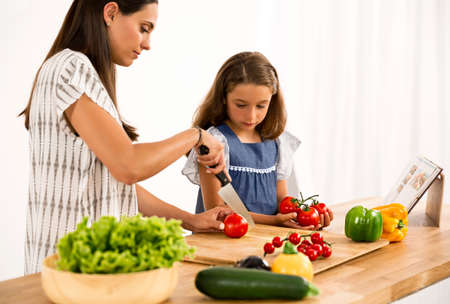 Shot of a mother and daughter having fun in the kitchenの写真素材