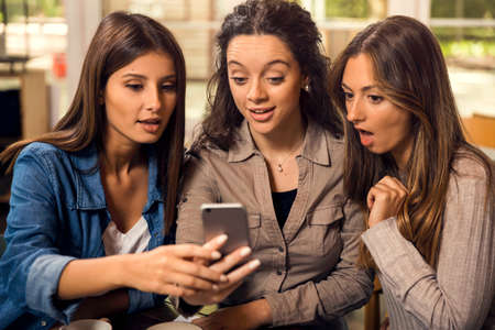 Group of girls making a pause on the studies for some gossipの写真素材