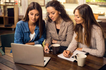 Group of beautiful female friends studying togetherの写真素材