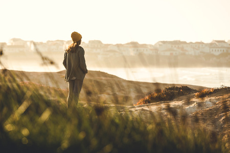 Woman with a yellow cap enjoying the viewの写真素材