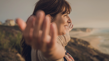Beautiful woman with arms raised enjoying the beautiful day