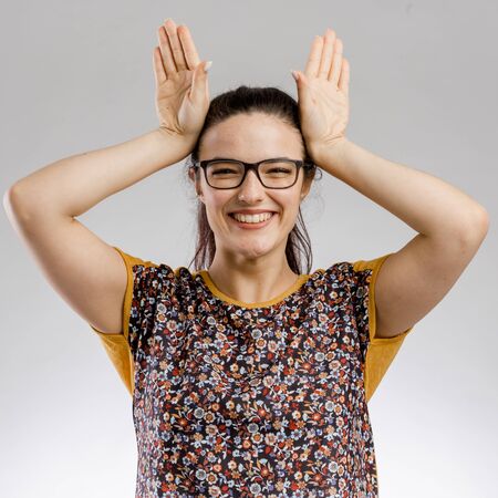 Funny portrait of woman making rabbit ears