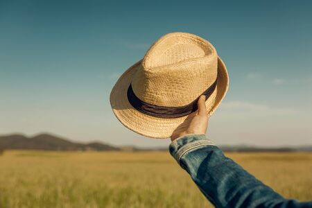 Female hand holding  a straw hatの写真素材