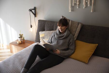 Beautiful woman on bed and reading a book