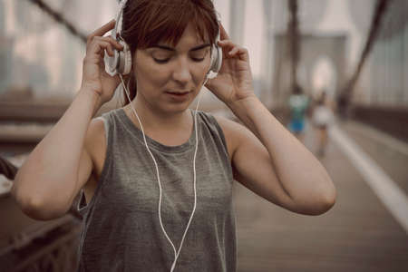 Woman on the Brooklyn bridge making a pause after the exerciseの写真素材