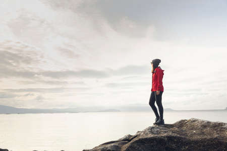 Woman enjoying the morning view of the coastの写真素材