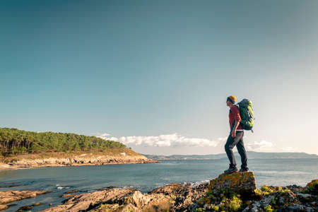 Shot of a man exploring the coastline with backpack