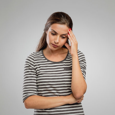 Portrait of a woman with a worried expression, overa gray backgroundの写真素材