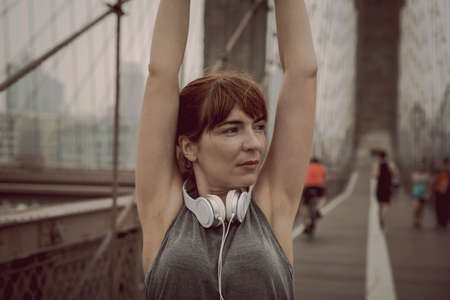 Woman on the Brooklyn bridge making a pause after the exerciseの写真素材