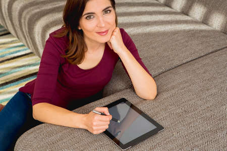 Gorgeous woman at home working with a tabletの写真素材