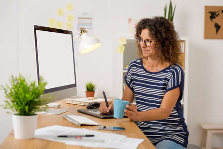 Middle aged woman at office making a phone call9の写真素材