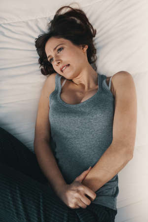 Portrait of a young woman in pain with PMS, Premenstural Syndromeの写真素材
