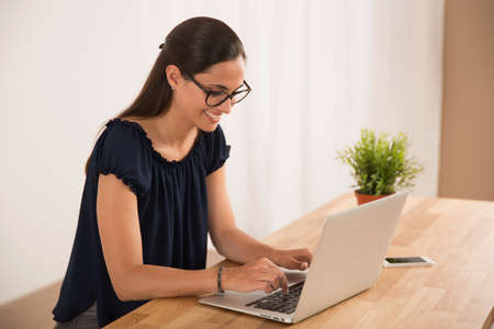Portrait of a happy businesswoman sitting at her desk in a home officeの写真素材