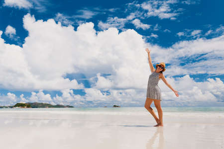 Beautiful woman on the beach enjoying the beauty of Praslin, Seychellesの写真素材