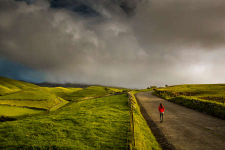 Woman standing on a top of a clif and enjoying the viewの写真素材