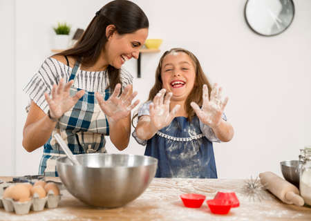 Shot of a mother and daughter having fun in the kitchen and learning to make a cake