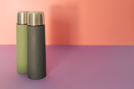 Two flasks - green and gray on a peach-fiolet backgroundの写真素材