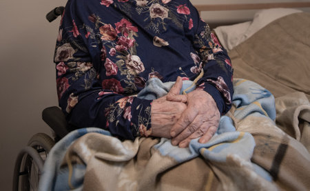 the hands of an elderly person sitting in a wheelchairの写真素材