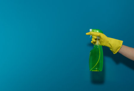 Female hand with a container of detergent. On blue backgroundの写真素材