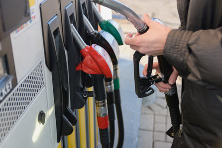 Using filling nozzles at a gas station. the woman takes out a filling pistol. selective focus