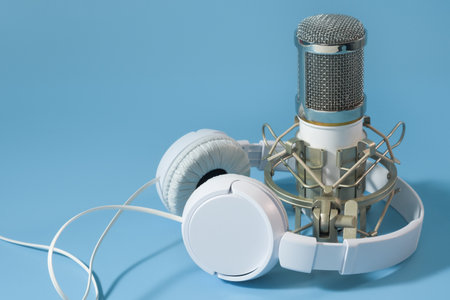 Headphones and microphone. Sound recording set of microphone and headphones on a blue backgroundの写真素材