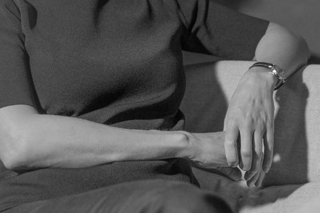 Hands of a young thin woman with wrinkled skin.の写真素材