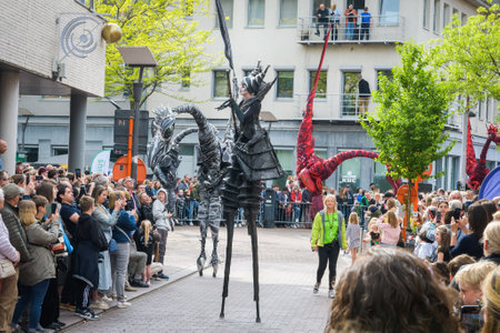 Genk. Limburg -Belgium 01-05-2022. Figure of dinosaurs and a girl on stilts. A spectacle for the citizens. Artists in costumes on the city street. O-parade Belgiumのeditorial素材
