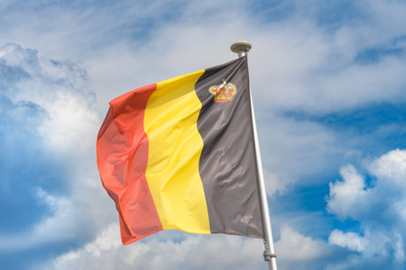 Flag of Belgium against cloudy a blue sky