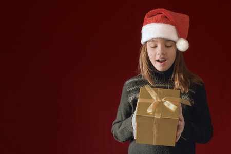 A Christmas banner with a teenage girl and a gift box. dark burgundy background. copy space
