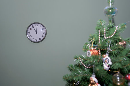 Wall clock at midnight and a decorated Christmas tree. Festive minimalismの写真素材