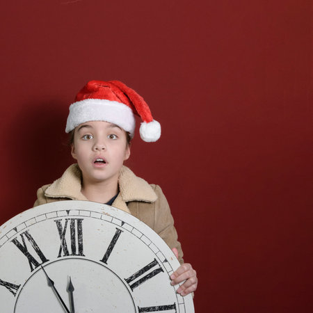Five minutes to the new year. A girl with a big old wall clock in her hands. square format. Wearing...