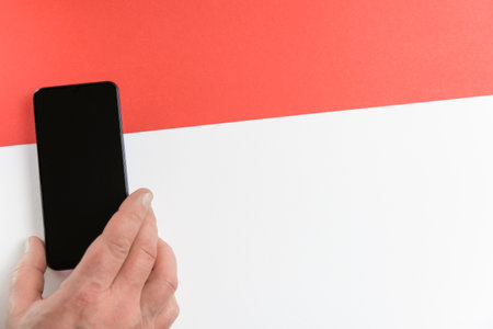 Red line. Hand with smartphone on red and white background.の写真素材