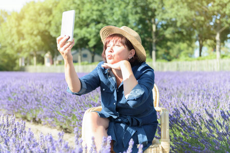 Summer selfie on a Lavender fields, woman taking a selfie. Summer lifestyleの写真素材