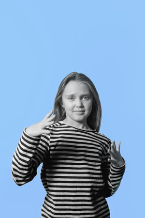 Negative emotions. The girl expresses displeasure. Black and white portrait of a girl on a blue backgroundの写真素材