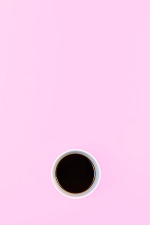 White cup with soy sauce on a pink background. Minimalistic, vertical. place for textの写真素材