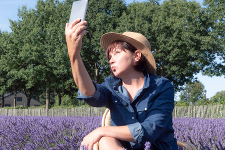 A woman taking a selfie. Summer lifestyleSummer selfie on a hot day. Lavender fieldsの写真素材